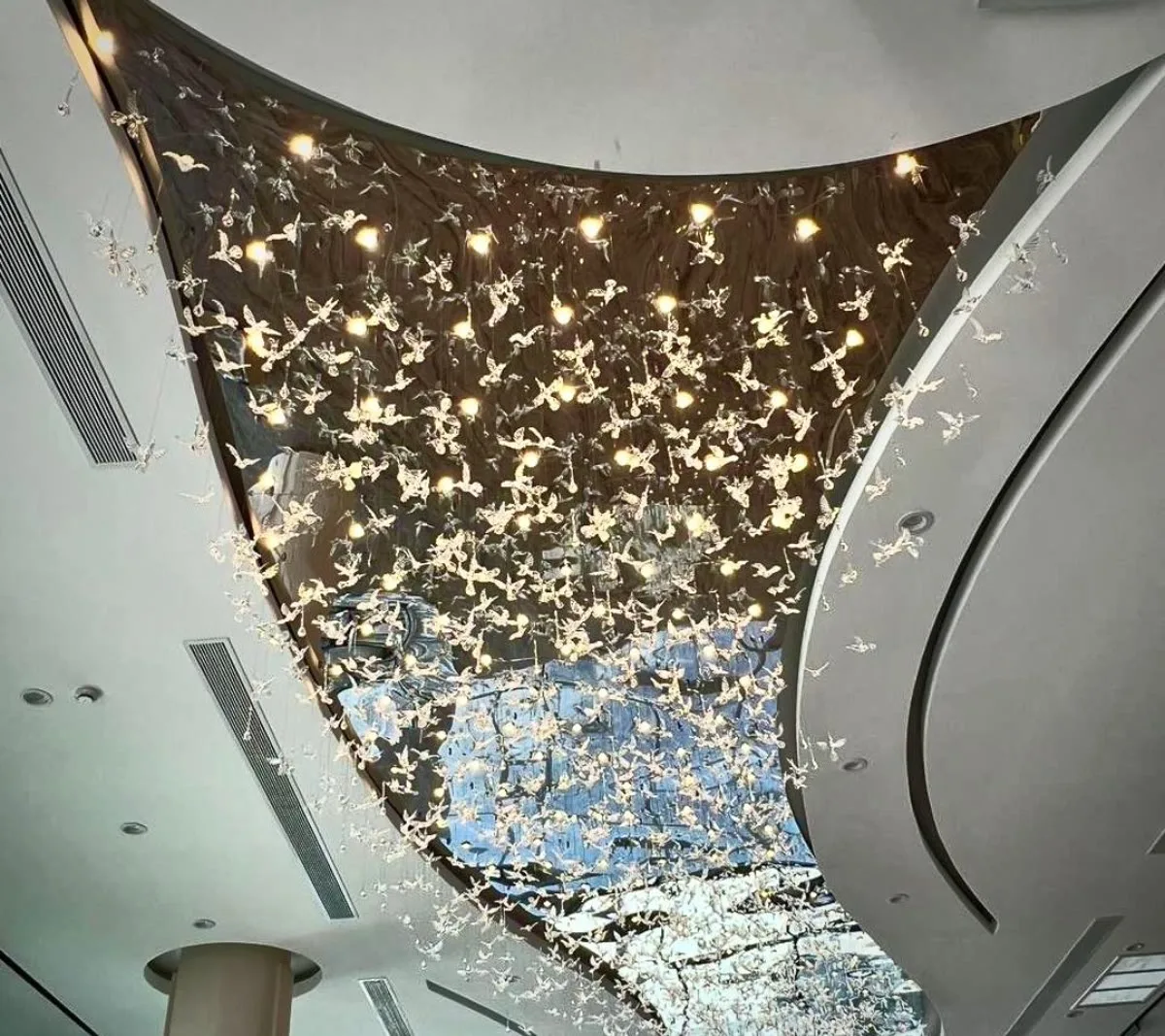 A crystal bird ceiling installation over a curved lobby